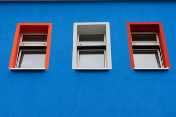 Obraz na płótnie Canvas colored windows in a blue wall