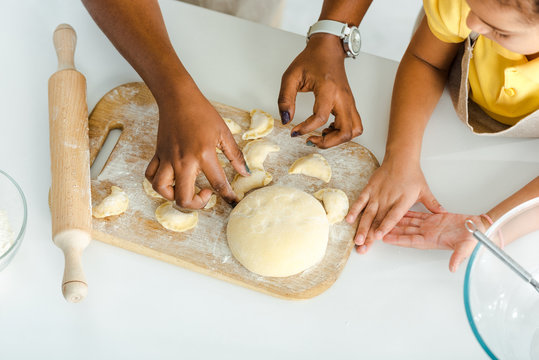 cropped view of african american mother and kid sculpting dumplings