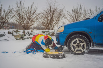 Man with towing rope hooks near towed car