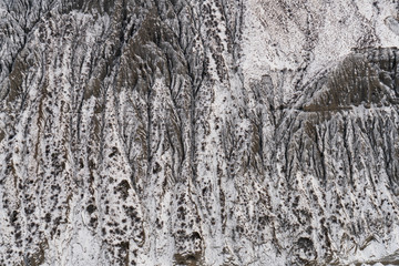 Fototapeta na wymiar China Xinjiang AnJiHai (Hongshan) Grand Canyon in winter with snow covered. Grey and red rocky cliff.