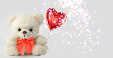 Cute teddy bear holds a heart ball. Valentine with a bear.