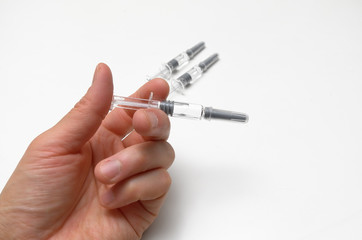 Generic prefilled vaccine syringes. Man&rsquo;s hand holding vaccine syringe.