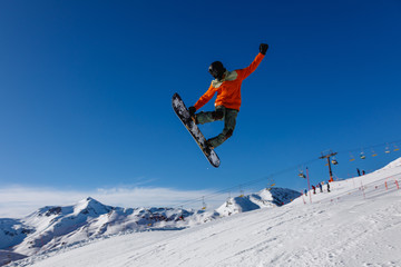 Naklejka na ściany i meble Snowboarder does the jumping trick. Livigno, Italy
