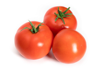 three fresh tomatoes with green leaves isolated on white background