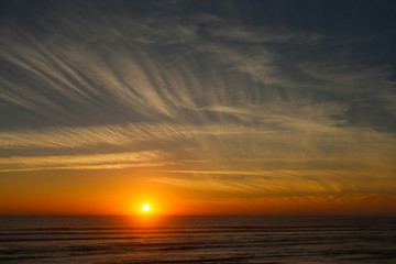 Naklejka na ściany i meble Sunset on the ocean with beautiful clouds