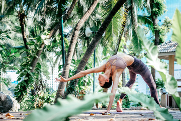 Just be. Full-length shot of caucasian woman standing in Wild Thing pose, Camatkarasana while practicing yoga outdoors, in a garden. Healthy lifestyle and relaxation concept