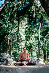 Breathe. Grow. Live. In yoga. Full-length shot of caucasian woman sitting in Butterfly pose, Baddha Konasana while practicing yoga outdoors, in a garden. Healthy lifestyle and relaxation concept