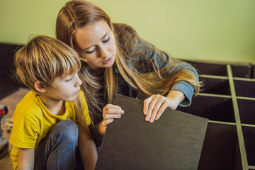 Mother and son assembling furniture. Boy helping his mom at home. Happy Family concept