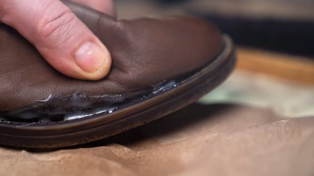 Shoe repair - glue the sole. Closeup.