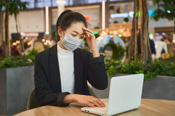 Alarmed female wears medical mask to protect against coronavirus, afraid of infection. Concept...