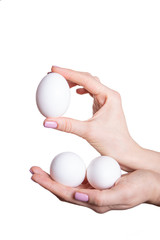 Fototapeta na wymiar Cropped view White eggs in female hands on a white background isolated