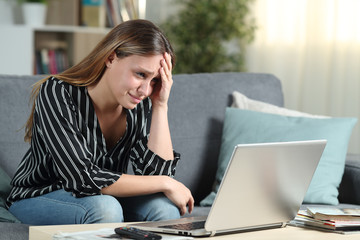 Worried homeowner checks laptop news