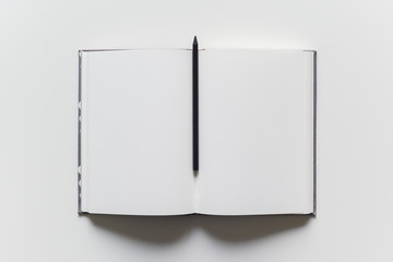 Empty blank white page in a paper note book with pencil for writing ideas and notes