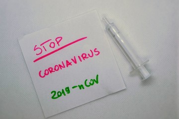 Novel coronavirus (2019-nCoV) lettering on the sheet of paper and syringe. Coronavirus (2019-nCoV), MERS-Cov (middle East respiratory syndrome coronavirus).  Pandemic virus. Chinese, Wuhan virus