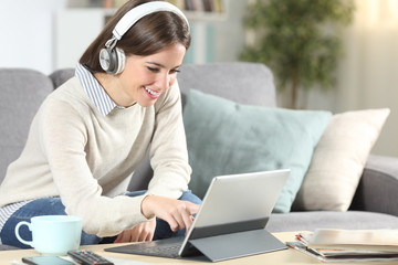 Happy woman using a convertible laptop at home