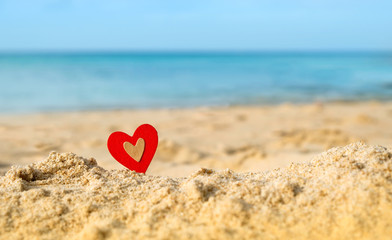 Fototapeta premium heart on sea coast. Love on sand beach. red heart on tropical seascape background. Valentine's day, love of travel, romantic vacation concept. copy space