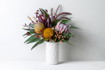 Beautiful floral arrangement of mostly Australian native flowers in a vase, including protea,...