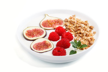 Yoghurt with raspberry, granola and figs in white plate isolated on white background. side view.