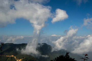 View from the top of Chandragiri hills with clouds on the first plan and the himalayas on the back