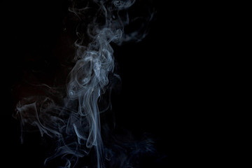 Abstract smoke from incense and light in a black background