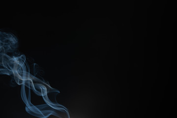 Abstract smoke from incense and light in a black background