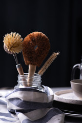 Close-up of coconut and sisal cleansing brushes on a kitchen table. Zero waste concept