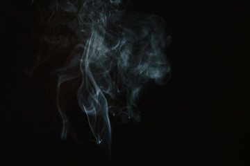 Abstract smoke from incense and light in a black background