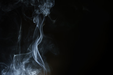 Abstract smoke from incense and light in a black background