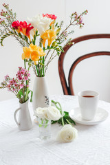 Coffee table styling with colorful spring flowers. Spring still life composition. Morning coffee with flowers
