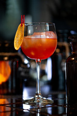 Venetian spritz cocktail  at bar counter in night club or restaurant. Close-up.