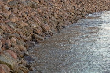 Rocky embankment on the river bank. . Big stones by the river