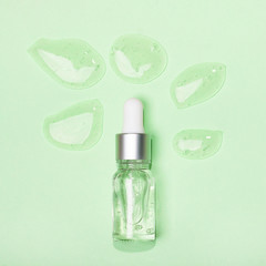 Face serum close-up on the trendy mint background. Collagen, hyaluronic acid for skin care. Achievements of modern science in cosmetic to preserve beauty.
