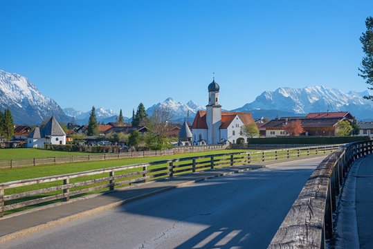 view from the main road to wallgau village, with traditional bavarian church, mountain landscape bavaria in spring