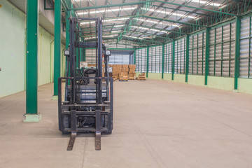 Forklifts inside empty warehouse with boxes background.
