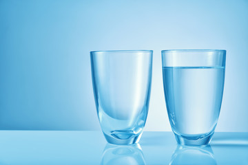 Glasses of fresh water on color background