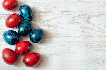 Easter background with Easter blue and red quail eggs. Copy space. Flat lay.