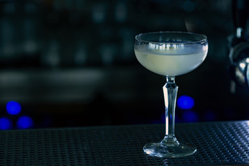 Daiquiri cocktail at bar counter in night club or restaurant. Close-up.