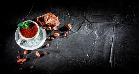 Portion of homemade mint hot chocolate in a cup on dark background