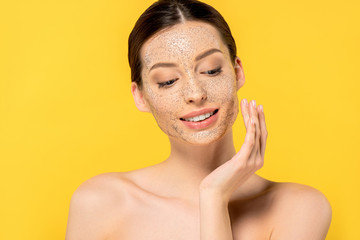 portrait of happy nude girl applying mask, isolated on yellow