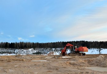 Excavator working in the mining quarry in winter time.  Excavator bucket. Large metal iron ladle....