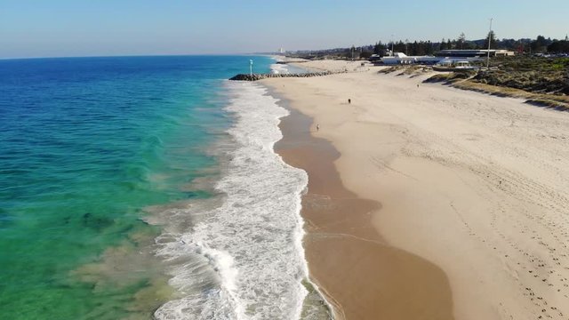 An aerial view of waves breaking onto the sand early in the morning at City Beach in Perth, Western Australia.