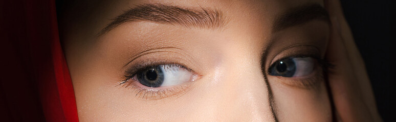 Obraz premium cropped view of attractive young woman with red scarf, isolated on black, panoramic shot