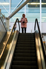 Woman with a camera on an escalator