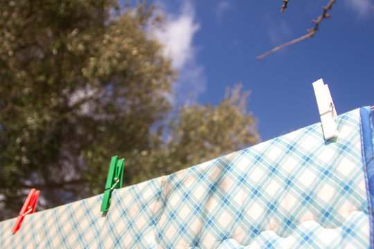 Very Close Up Of Clothes With Colorful Bed Sheets Hanging On The Wire With Colored Clothespins For Hanging Out The Laundry Fluttering In The Wind