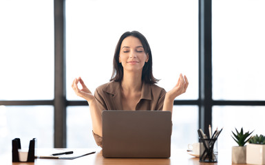 Girl meditating in office coping with stress - obrazy, fototapety, plakaty