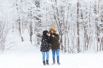 Fototapeta na wymiar Happy loving couple having fun outdoors in snow park. Winter vacation