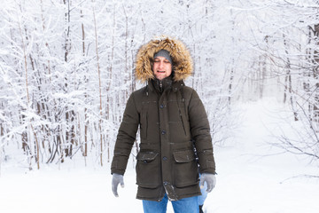 Fototapeta na wymiar Handsome man in winter hat funny portrait on snowy nature