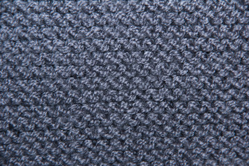 Grey textile background. Knitting with grey yarn. The texture of the knitted fabric.