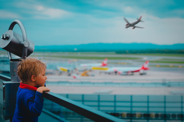 Fototapeta na wymiar cute little boy looking at planes in the airport