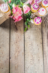 Happy moms day greeting background. Mothers day sweet cupcakes, with gift boxes, coffee cappuccino cup, flowers. Wooden background copy space